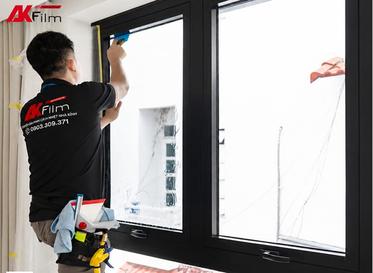 Kỹ thuật viên dán phim cách nhiệt cho hệ kính nhà phố